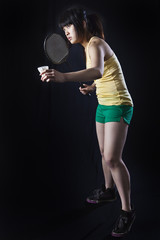 Asian woman with badminton racket isolated on black