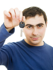 Fototapeta premium Young man holding keys in his hand, white background