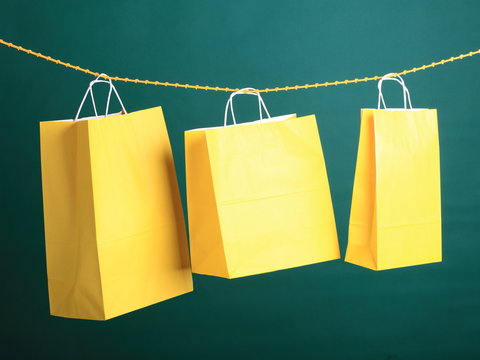 Shopping yellow gift bags on green background