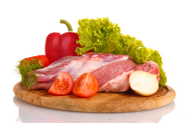 Raw meat and vegetables on a wooden board isolated on whitе
