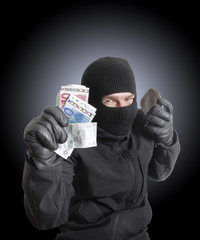 Masked criminal holding a stolen leather purse