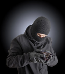Masked criminal holding a stolen leather purse