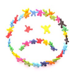 unglückliches Smiley Gesicht aus vielen Knetfiguren