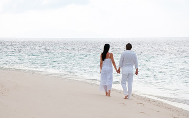 Fototapeta na wymiar Picture of romantic young couple having a walking on the sea sho