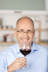 lächelnder mann mit einem glas rotwein
