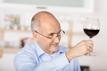 lächelnder mann prostet mit einem glas rotwein
