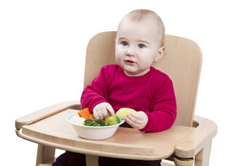 young child eating in high chair