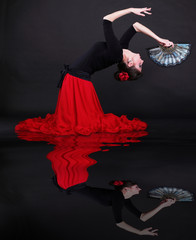 Attractive spanish young woman dancing flamenco over black backg - obrazy, fototapety, plakaty