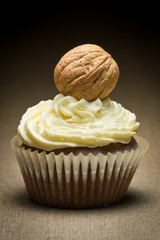 Brown muffin with vanilla cream and big walnut