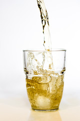 Apple juice, poured into a glass with ice cubes