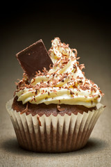 Brown muffin with chocolate chip and vanilla cream