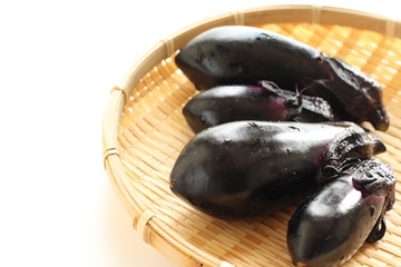 Eggplant on bamboo basket on white background