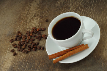 Coffee cup with beans and cinnamon sticks