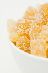 Ginger candy pieces in a white ceramic bowl
