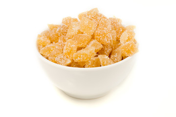 Bowl of crystallised ginger, against white background, close-up