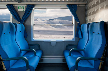 Window train with snow landscape and empty seats.