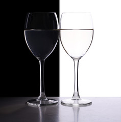 two wine glasses in backlight on the black and white background
