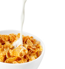 Milk with corn flakes on white.