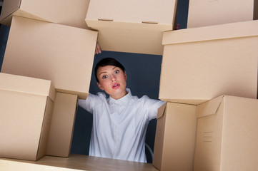 Portrait of young woman surrounded by lots of boxes