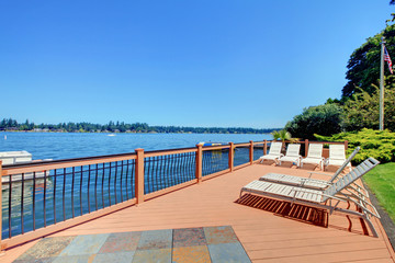 Lake waterfront deck with beach laying down chairs - obrazy, fototapety, plakaty