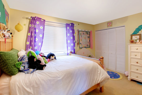 Baby girl room with toys and purple curtains.