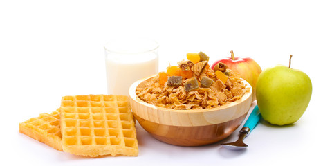 tasty cornflakes in wooden bowl, apples and glass of milk