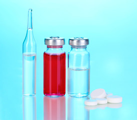 Tablets and ampoules on blue background