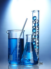 Test-tubes with blue liquid on blue background