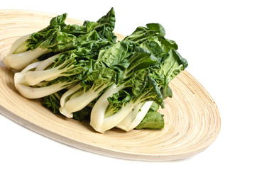 Bunch of Baby Bok Choy on a Bamboo Tray Isolated on White