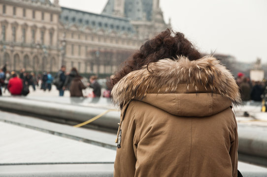 femme de dos admirant la cour du Louvre à Paris