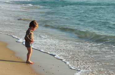 child at the sea on sunset colors