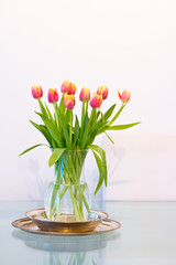 home decoration: vase of fresh orange tulips on glass table