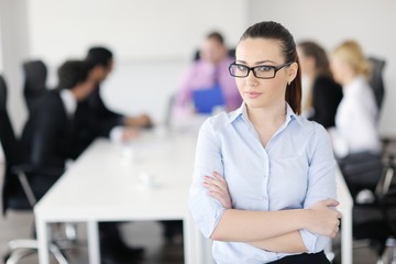 business woman standing with her staff in background