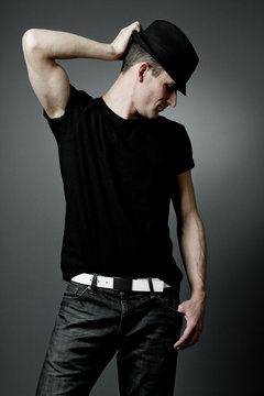 Handsome man posing in black t-shirt and black hat.