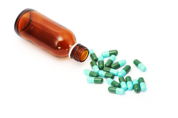 green pills and bottle ,isolated white.
