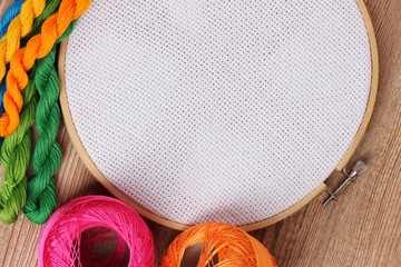 The embroidery hoop with canvas and bright sewing threads