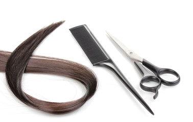 Shiny brown hair with hair cutting shears and comb isolated