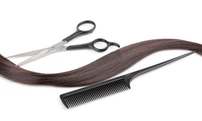 Shiny brown hair with hair cutting shears and comb isolated