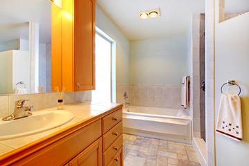 Large bathroom with double sinks and tub with grey rug.
