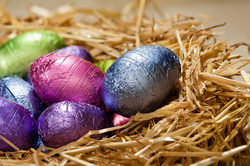 Chocolate Easter eggs in a natural straw nest