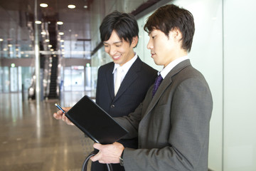予定を確認するビジネスマン2人