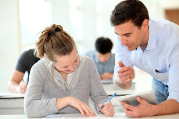 Teacher with student girl writing assignment