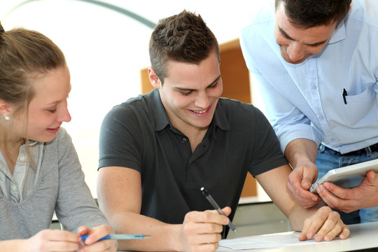 Teacher helping students with assignment