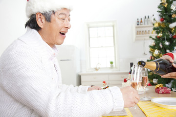 Obraz premium シャンパンを注いでもらうシニア男性