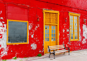 Bench in front of an old red restaurant in Hydra in Greece