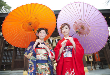 和傘を差す振袖姿の女性2人
