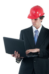 Young engineer with red helmet working on the notebook
