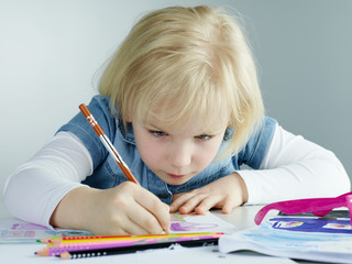 Cute child concentrated is painting a picture