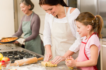3 generations of women baking apple pies