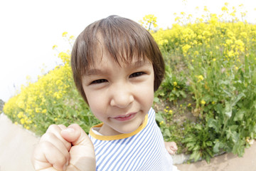 菜の花畑で微笑む男の子